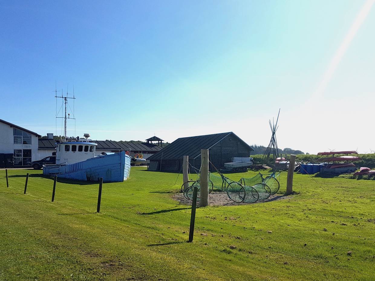 Rasenfläche mit FisReusen und einem SFischerboot zum Klettern