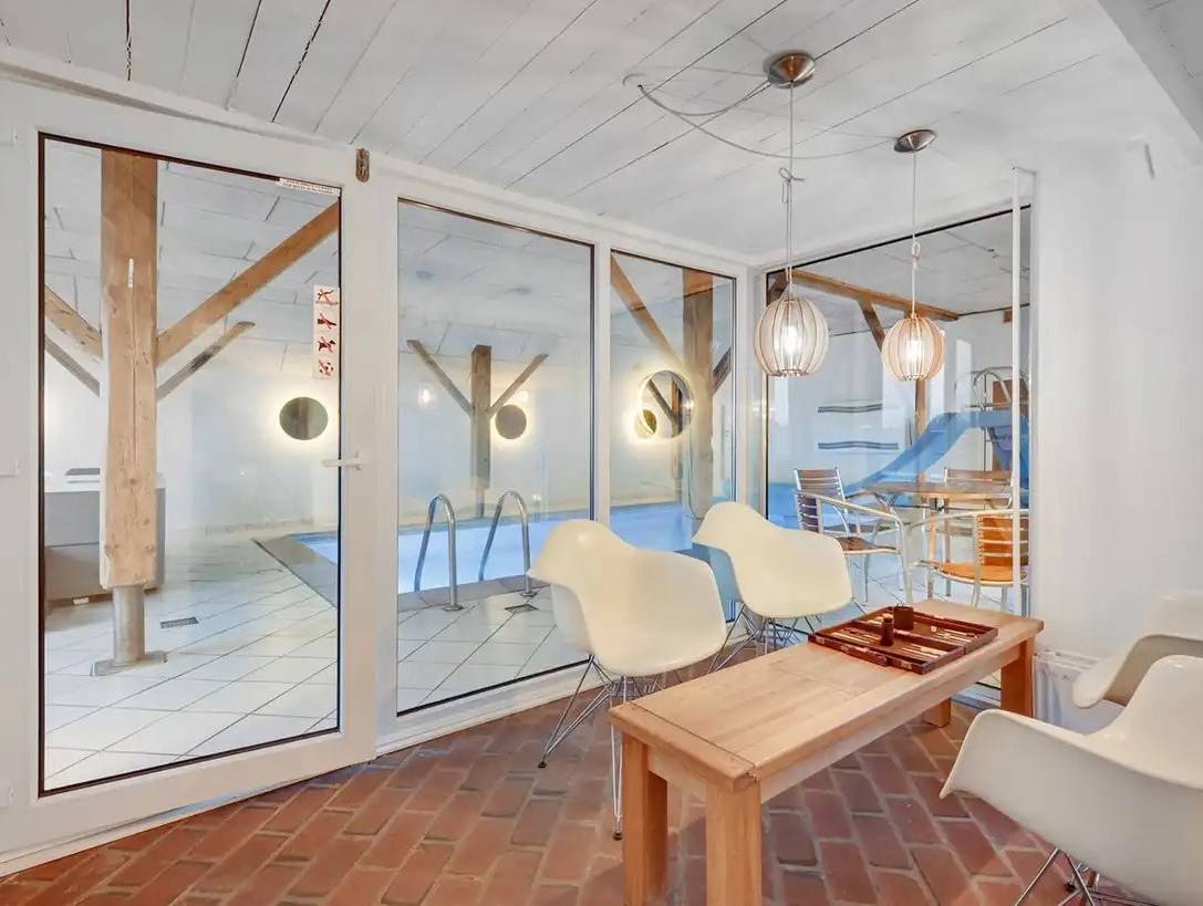 Spieltisch vor der Fensterfront zum Pool im Ferienhaus
