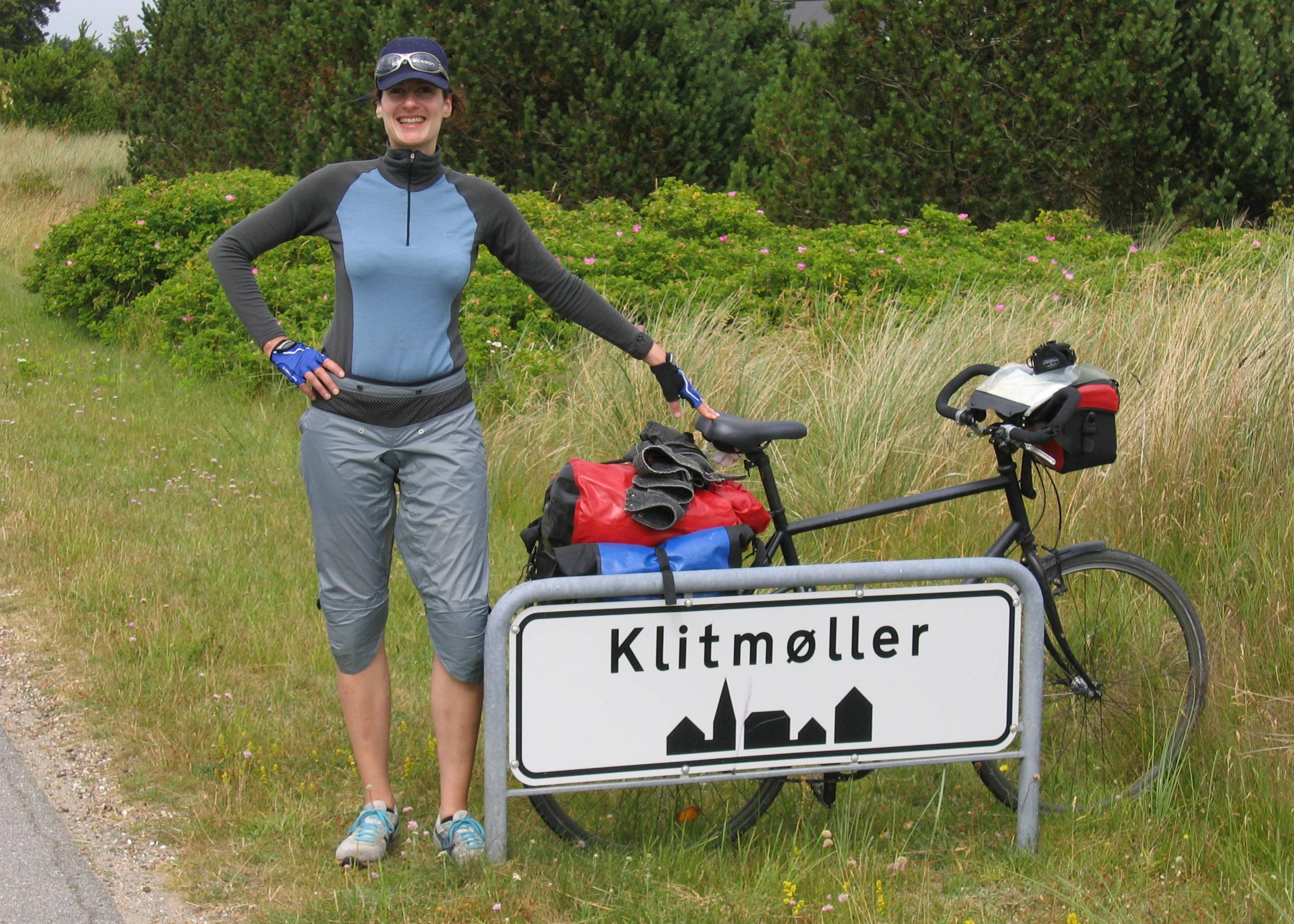 Radfahrerin am Ortschild von Klitmøller 