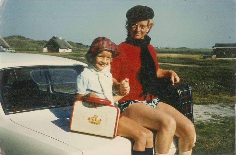 Mutter und Tochter sitzen mit Koffern auf dem Auto 