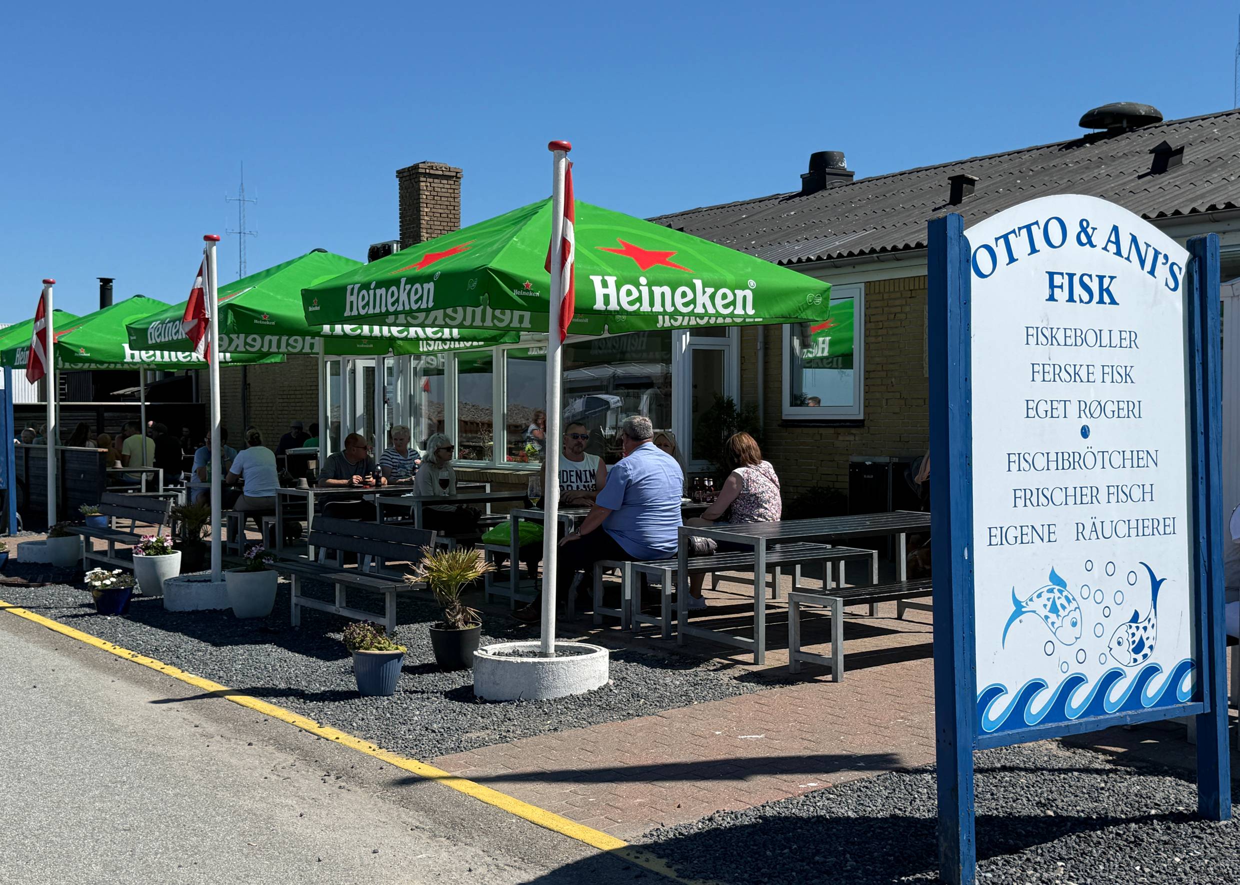 Fischgeschäft am Hafen mit vielen Gästen auf der Außenterrasse