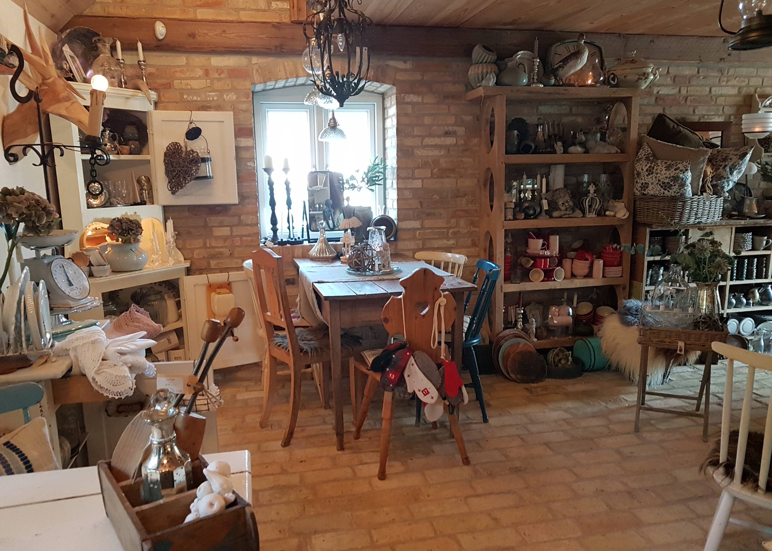 Rustikales Café mit viel Deko und Geschirr in den Schränken
