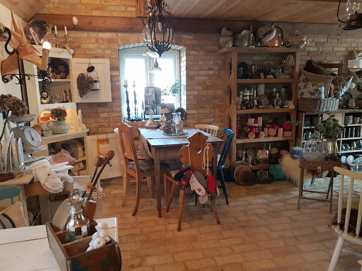Rustikales Café mit viel Deko und Geschirr in den Schränken