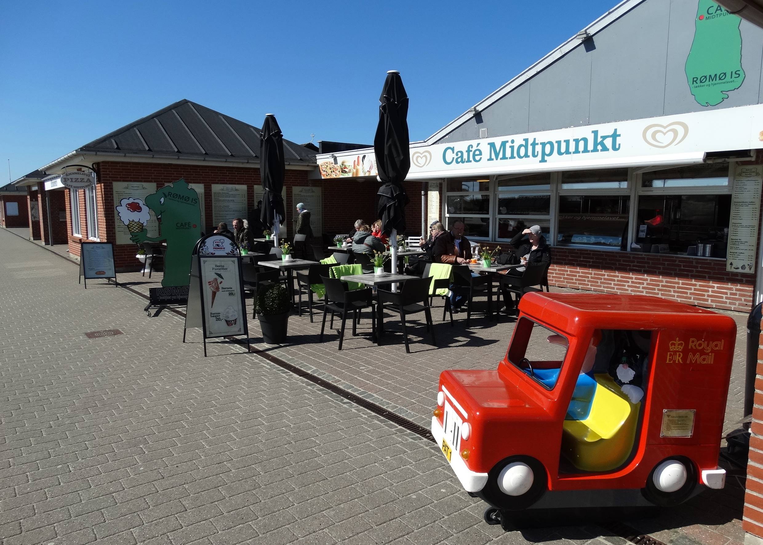 Eiscafé, davor ein großes, rotes Spielzeugauto