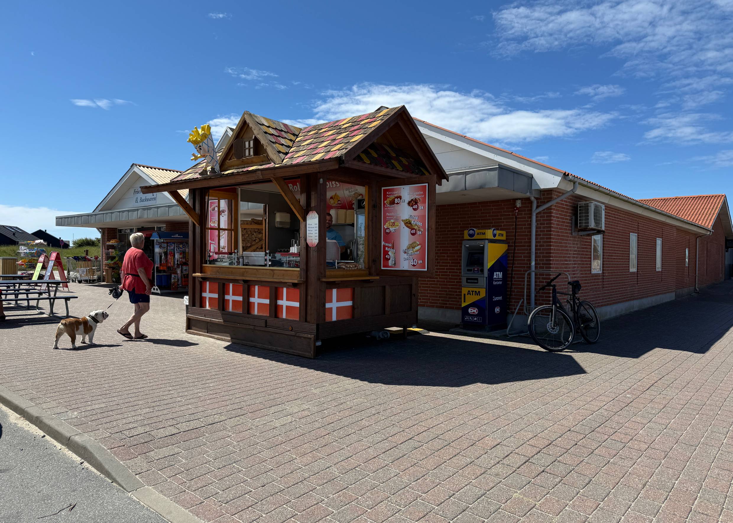 Kleine Holzhütte mit viele dänische Fahnen und eine Tüte Pommes Frittes auf dem Dach