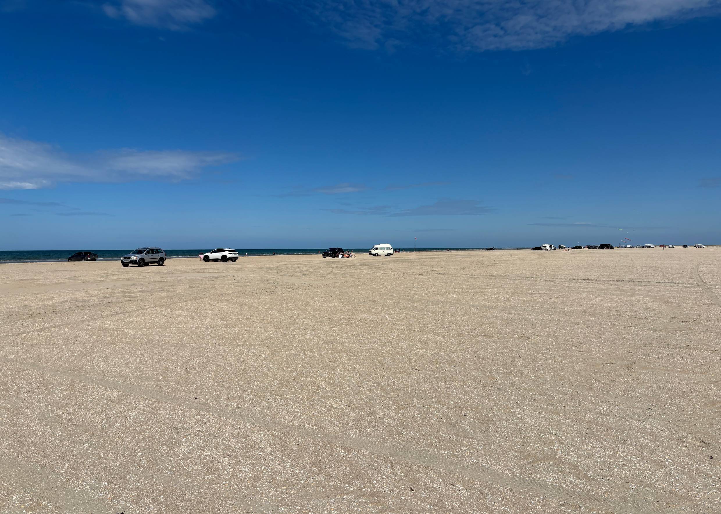 Blick auf zahllose Autos und Badegäste auf dem Strand