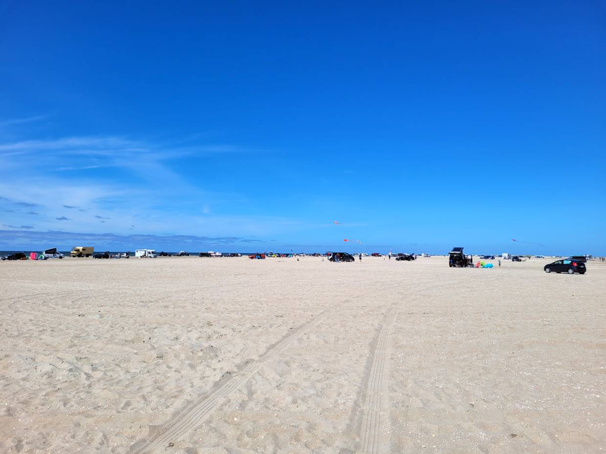 Blick auf zahllose Autos und Badegäste auf dem Strand