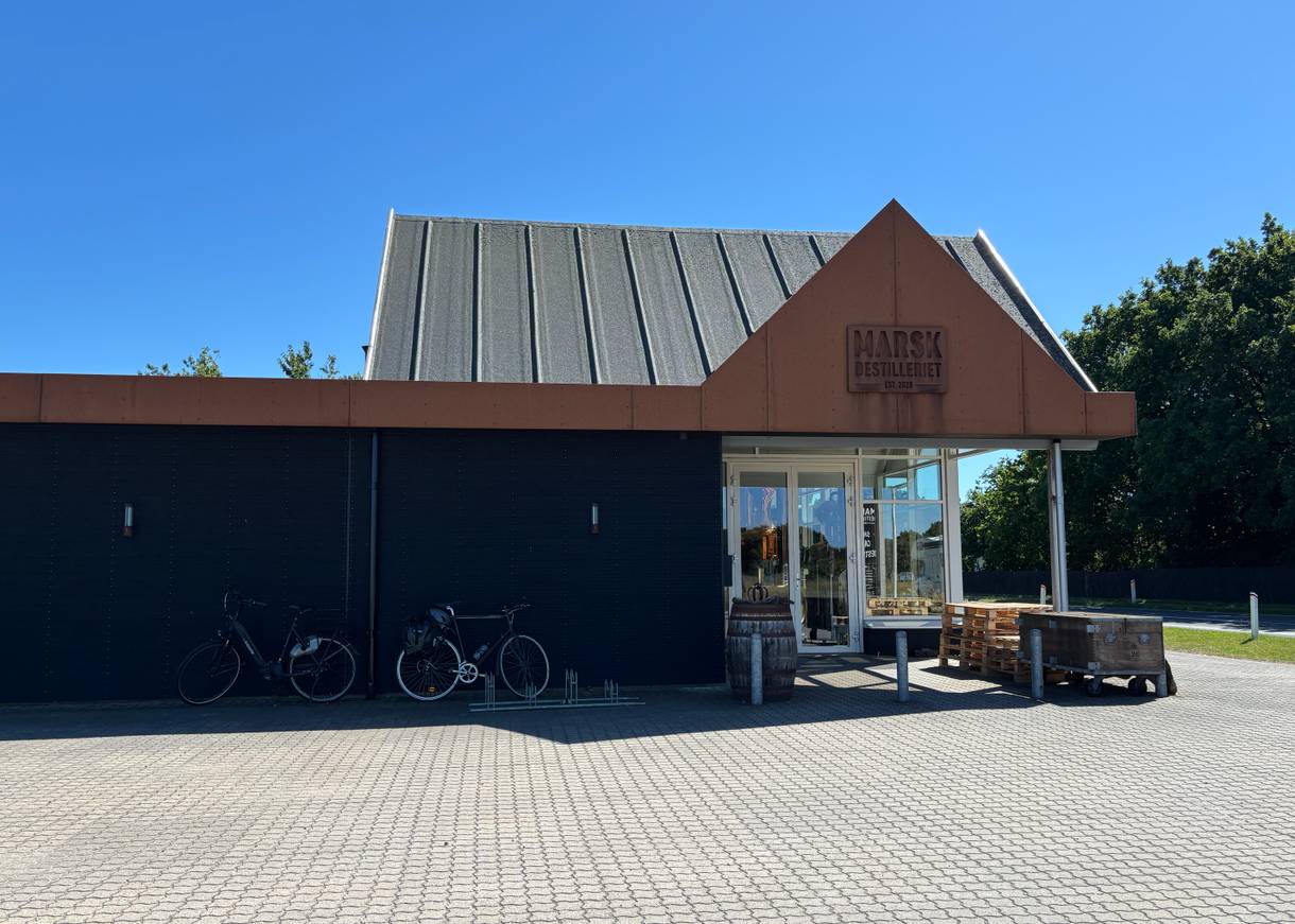 Neues Gebäude aus Holz und Metall, davor Paletten und Fahrräder