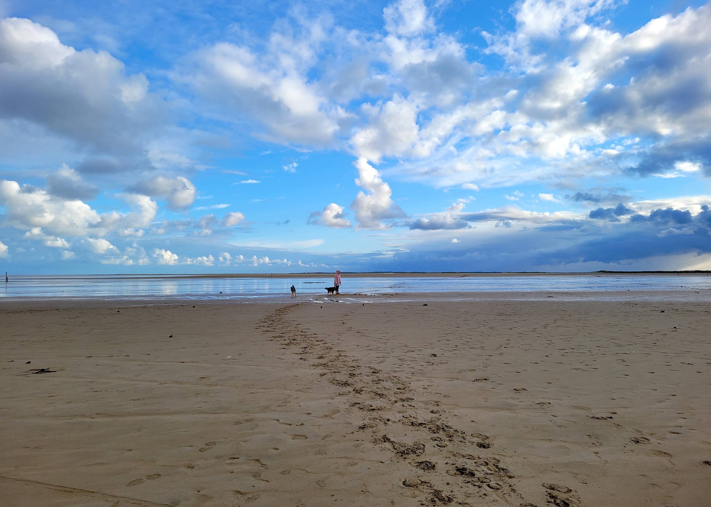 Wolkenberge am blauen Himmel über dem Strand