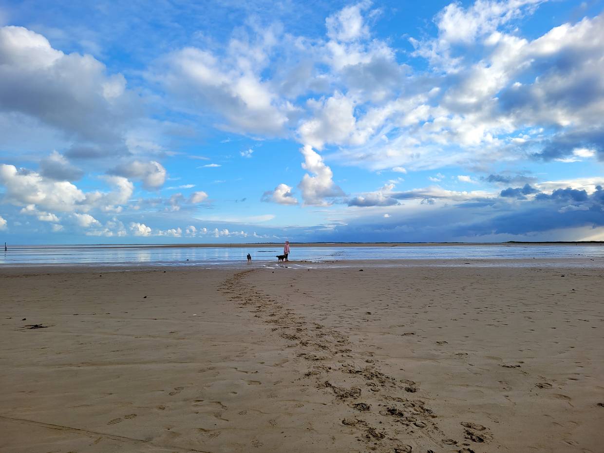 Wolkenberge am blauen Himmel über dem Strand
