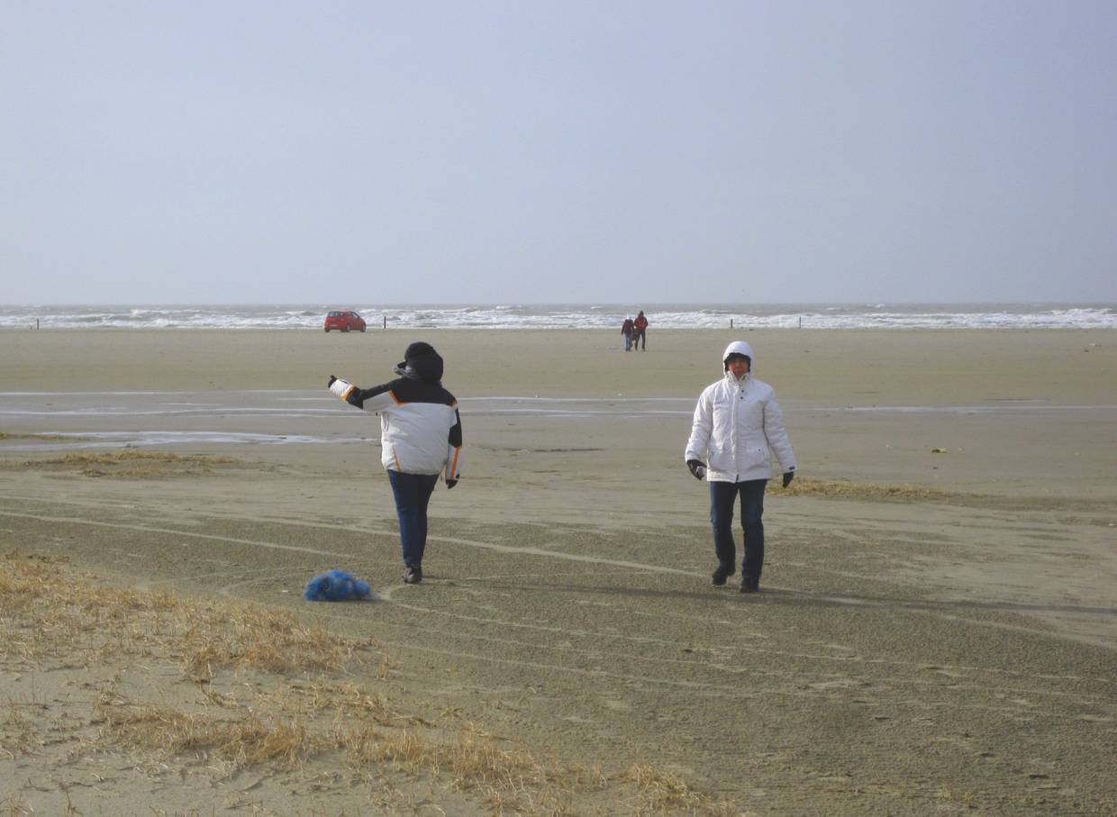 Spaziergänger in Winterjacken auf dem Strand von Rømø