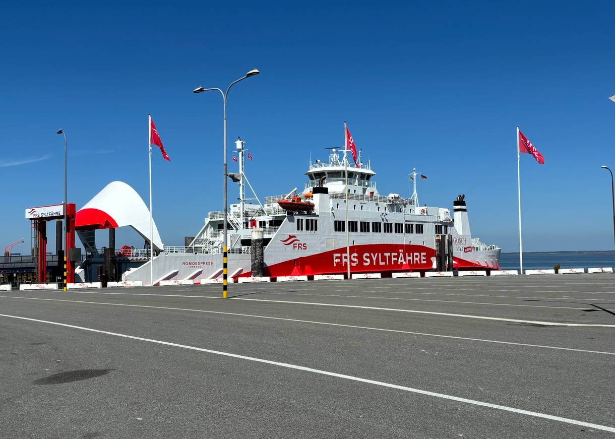 Eine kleine Fähre im Hafen, gestrichen ganz in rot und weiße Farben mit der Aufschrift Syltfähre