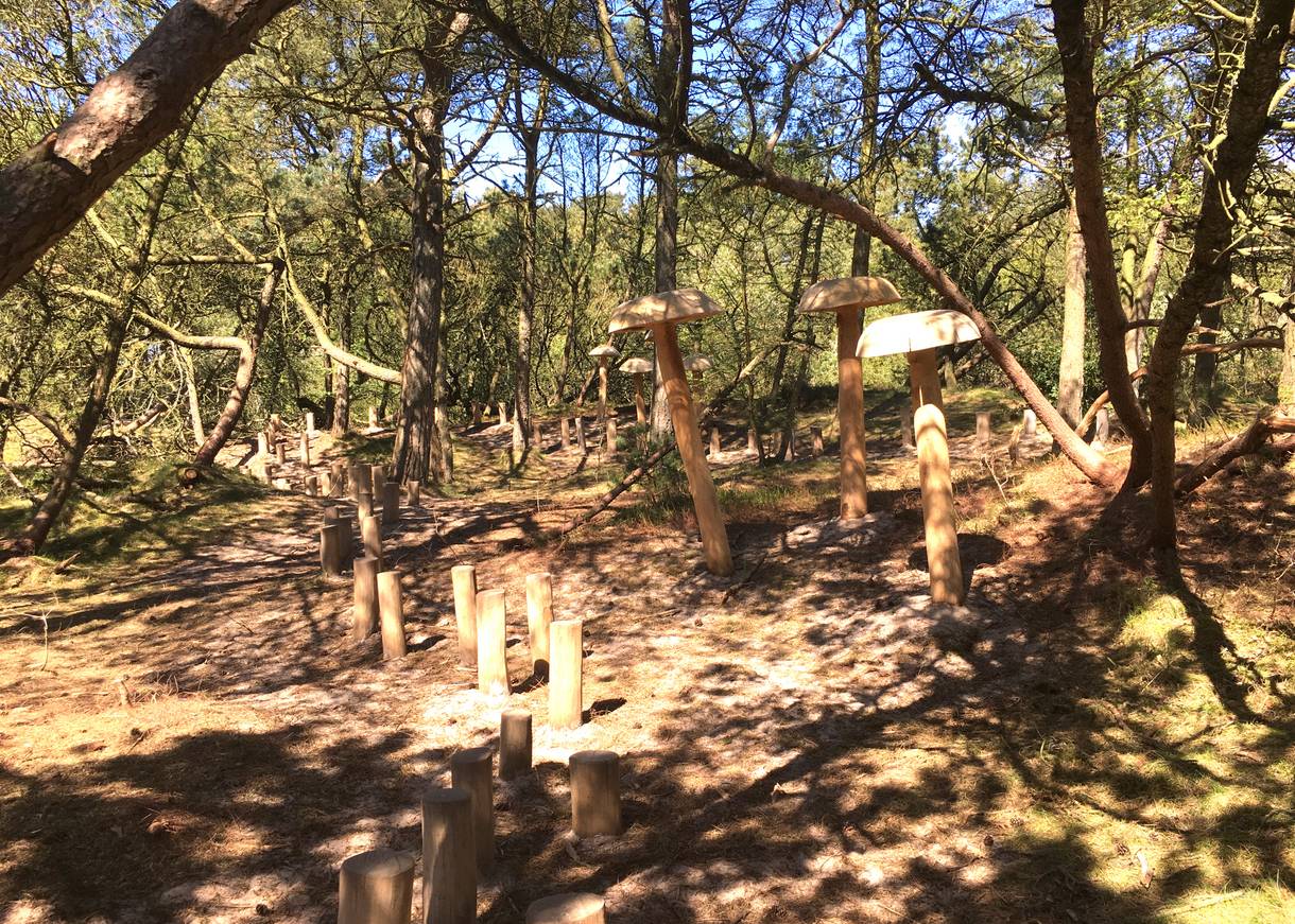 Holzfiguren in einem Kiefernwäldchen