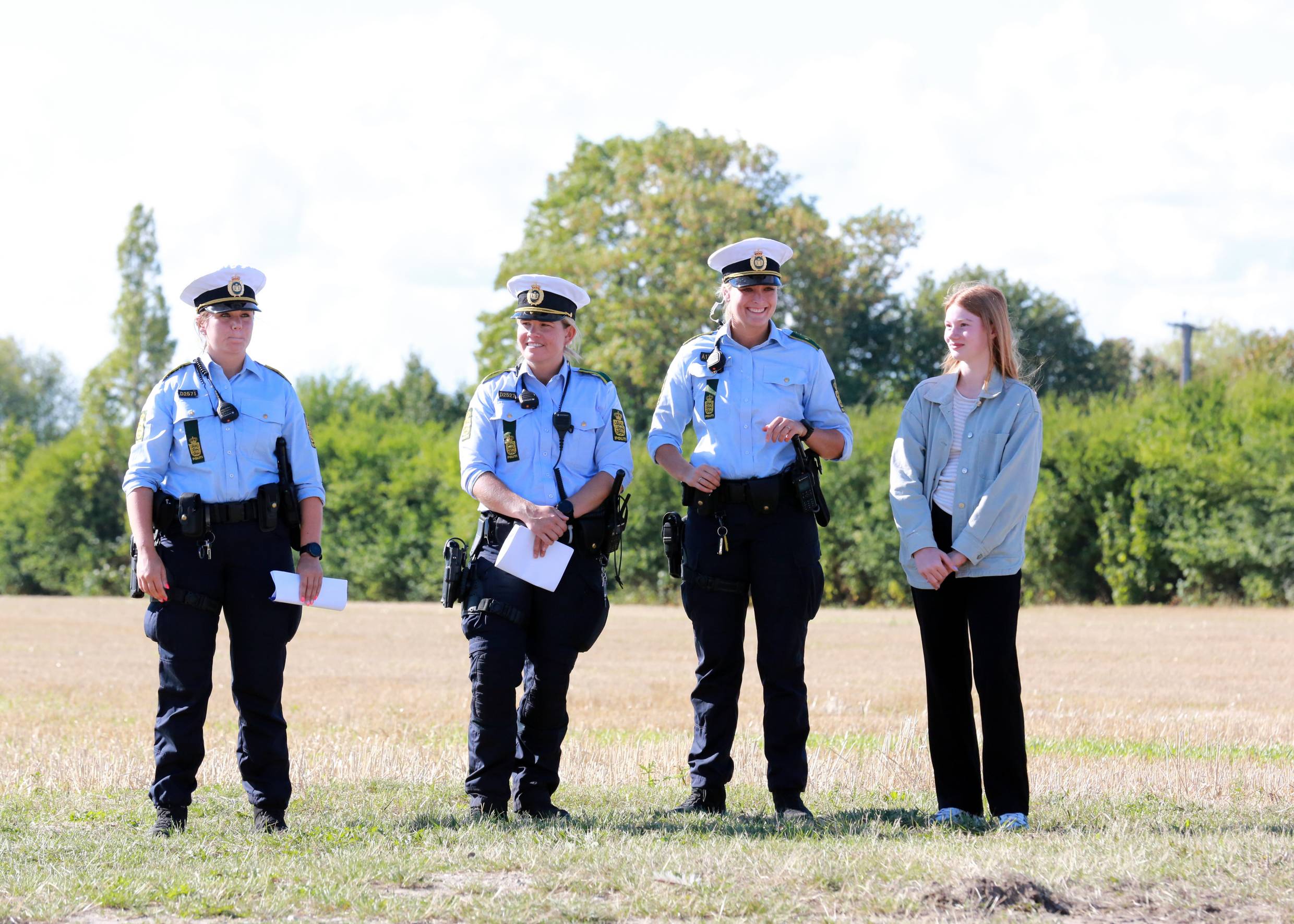 Drei Blonde Polizistinnen auf einem Feld