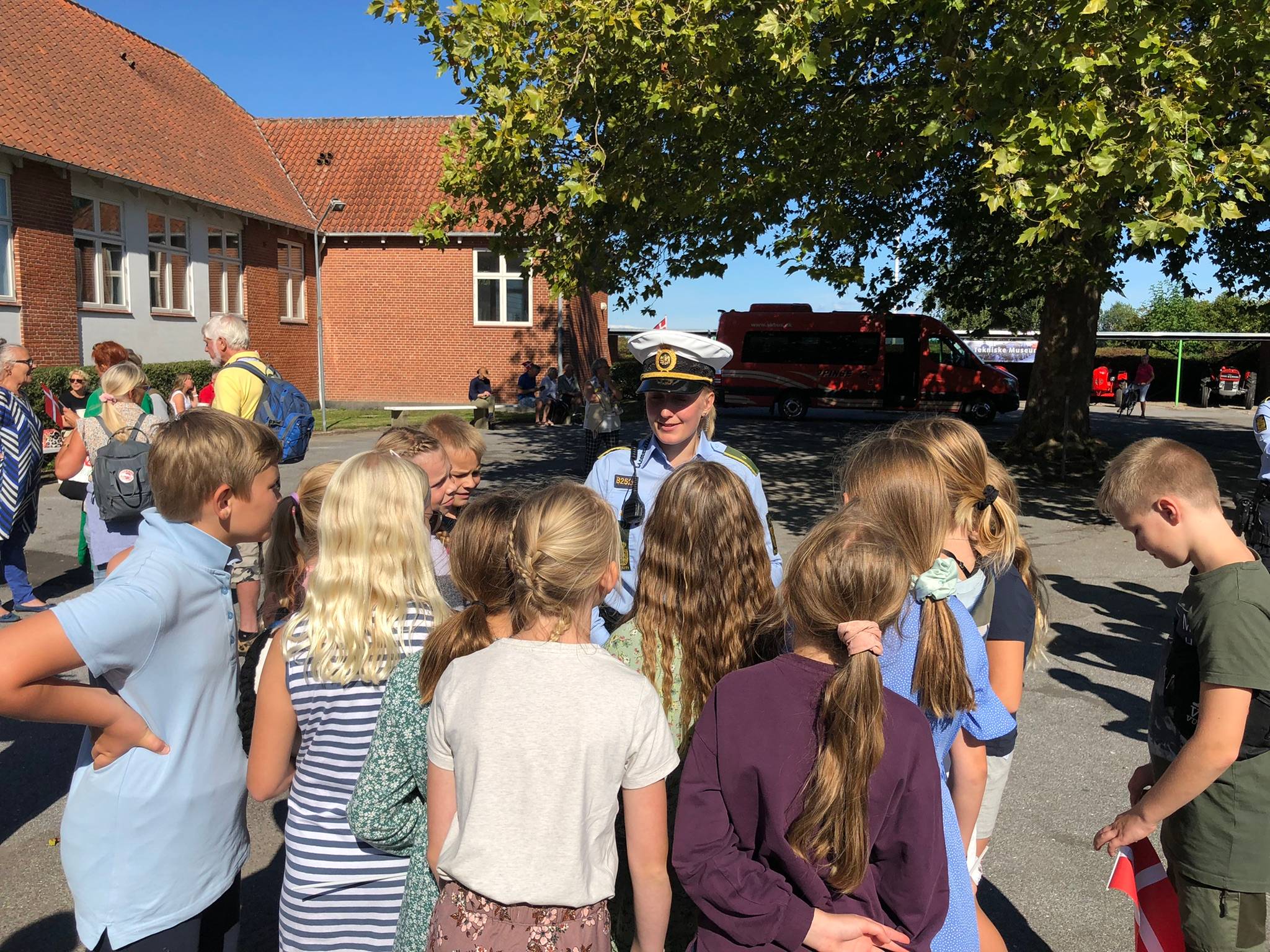 Eine Polizistin steht vor einer Kindergruppe im Schulhof
