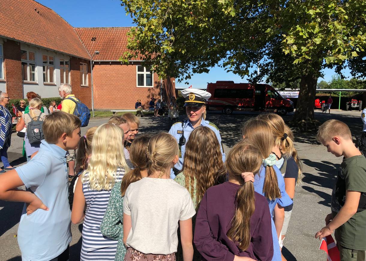 Eine Polizistin steht vor einer Kindergruppe im Schulhof
