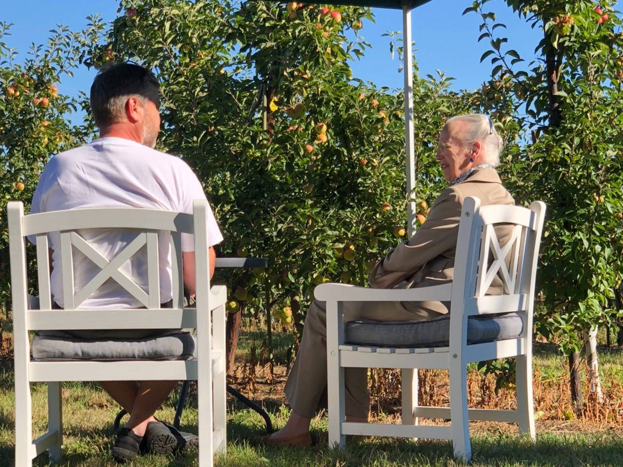 Königin Margrethe im Gespäch mit Obstbauer Jensen in seiner Plantage