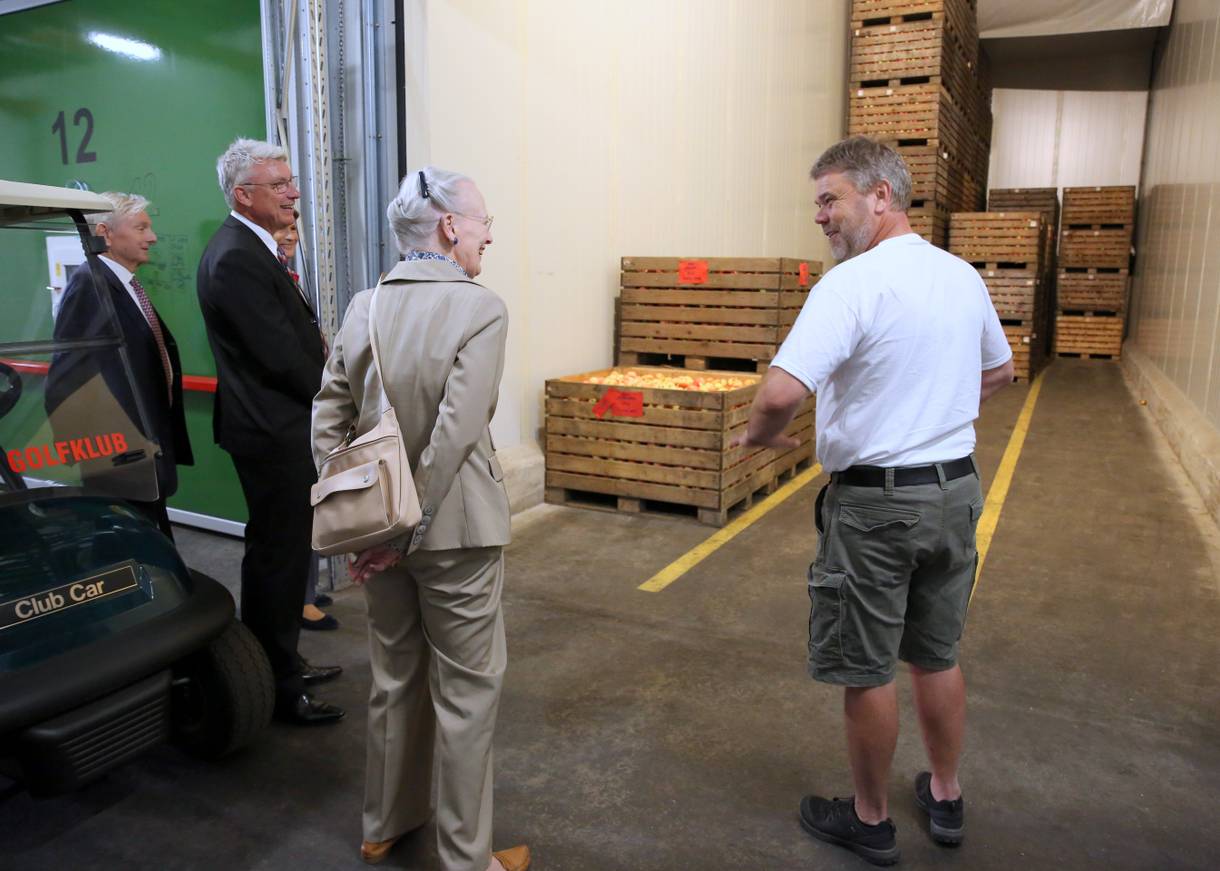 Königin Margrethe mit dem Obstbauer in einer großen Lagerhalle