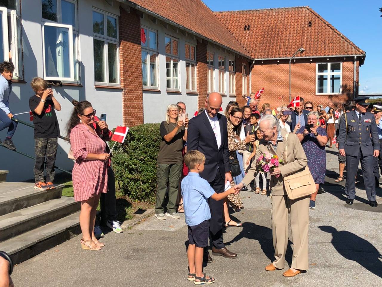 Die Königin bedankt sich für den nächsten Blumenstraß und der Junge ist sicher stolz