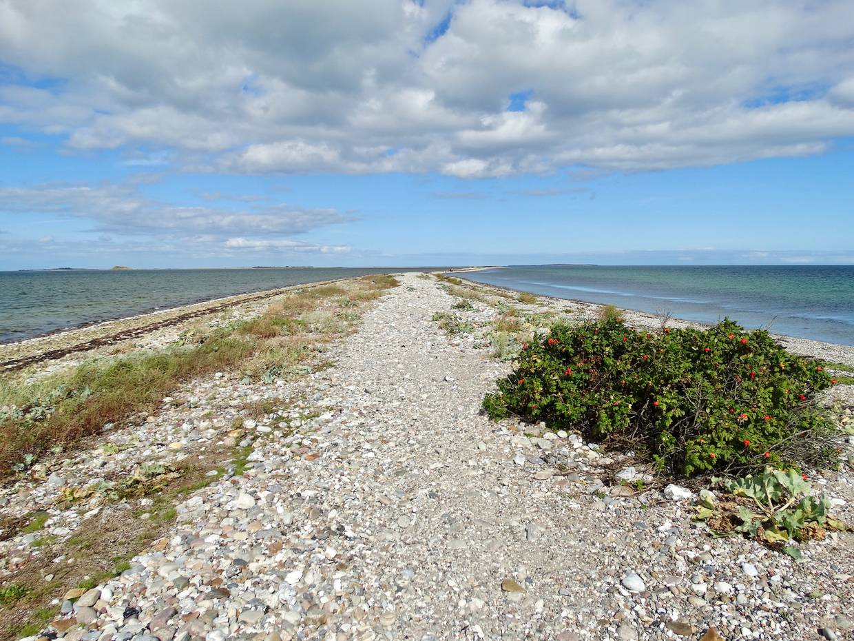 Schmaler Steinstrand, auf beiden Seiten von Wasser umgeben