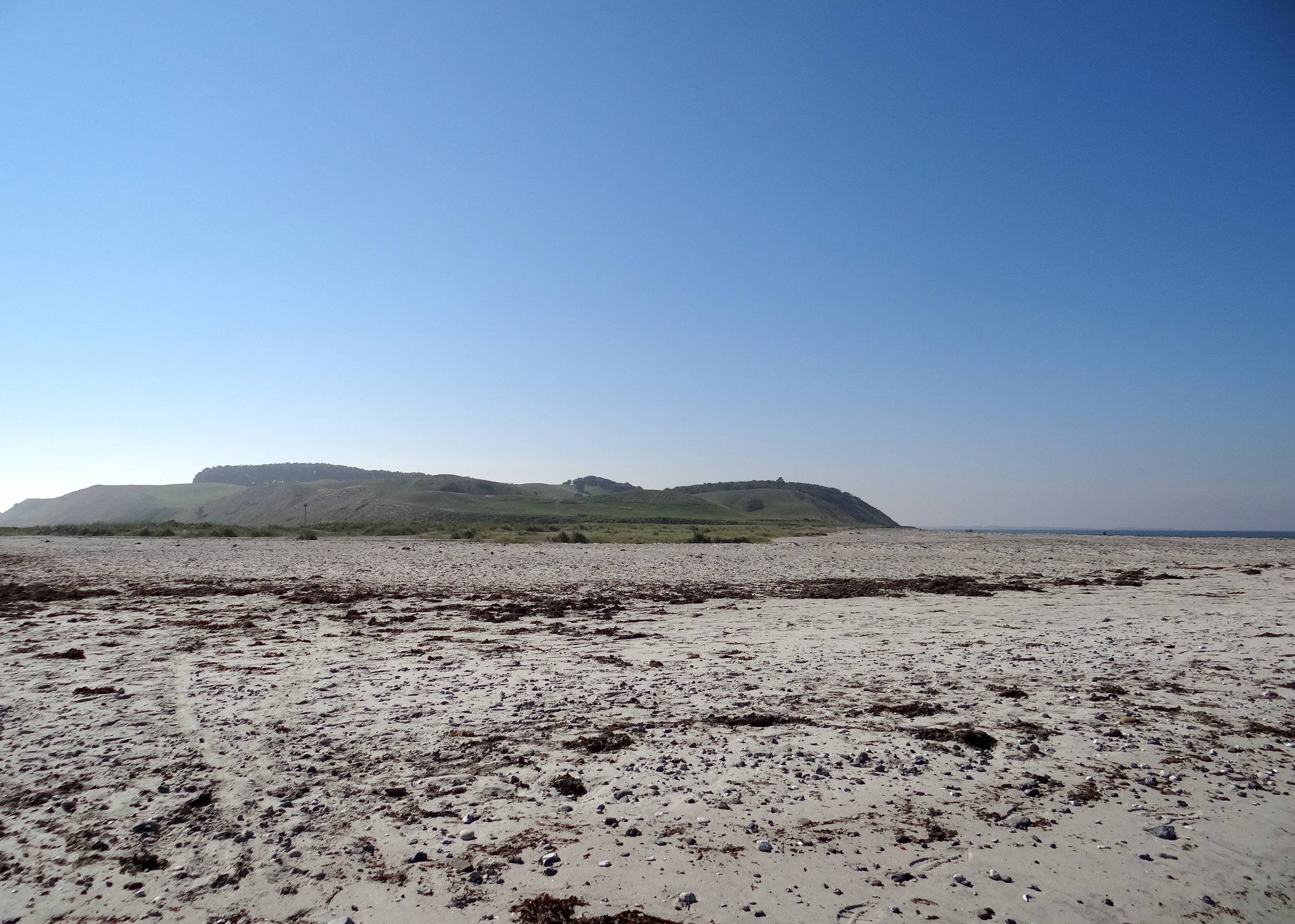 Blick vom Strand zu einer Hügelkette