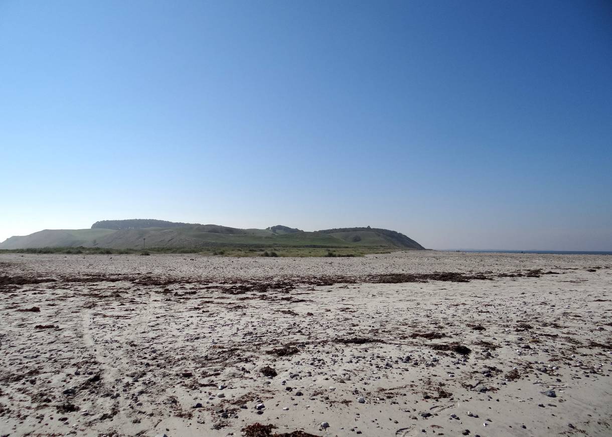 Blick vom Strand zu einer Hügelkette