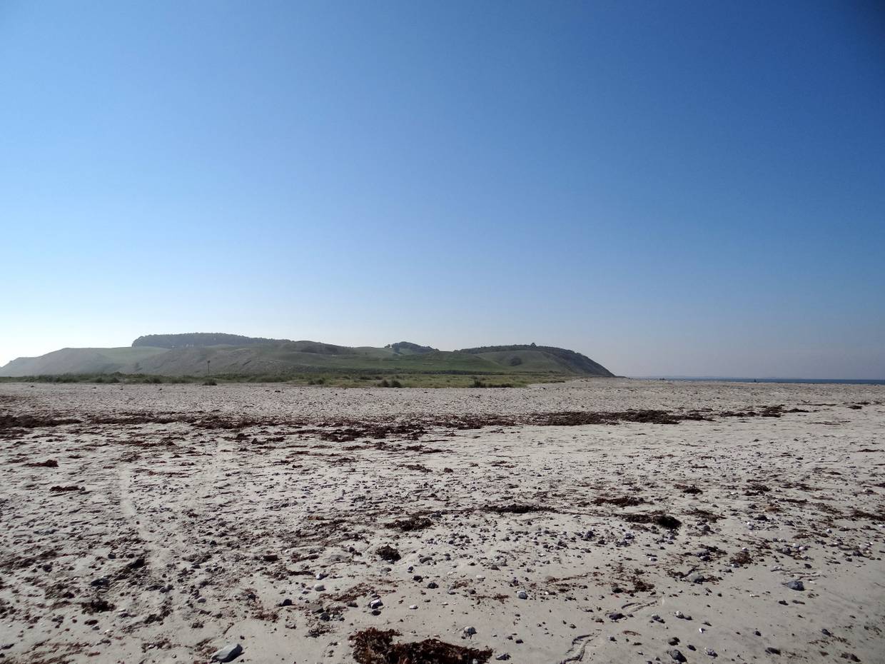 Blick vom Strand zu einer Hügelkette