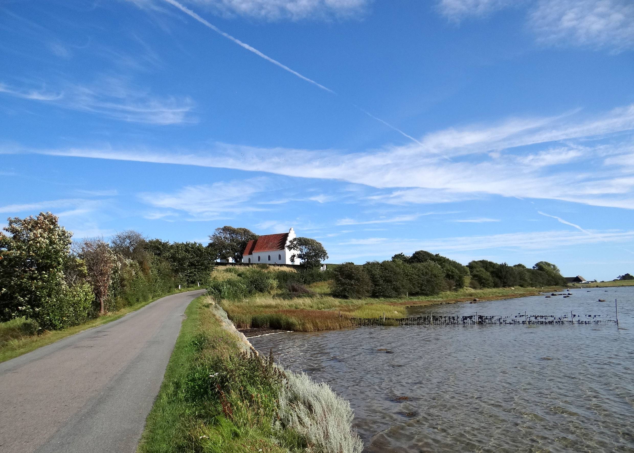 Kleine weiße Dorfkirche am Wasser