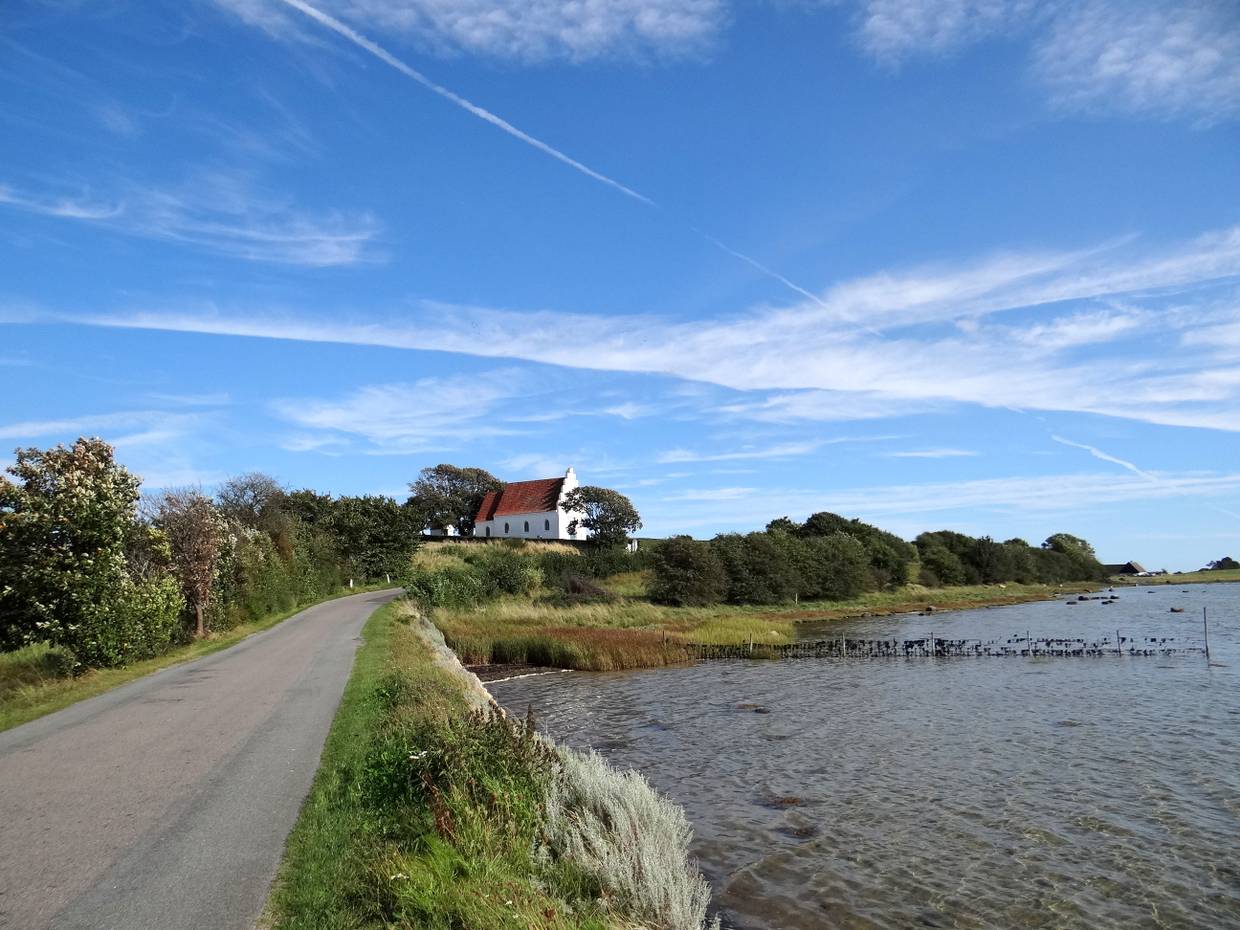 Kleine weiße Dorfkirche am Wasser
