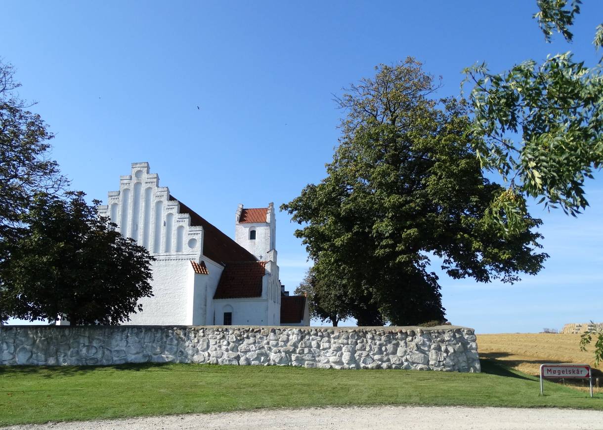 Weiße Kirche hinter einer flachen Steinmauer