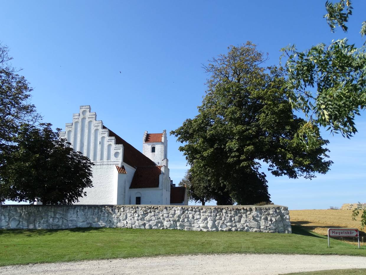 Weiße Kirche hinter einer flachen Steinmauer