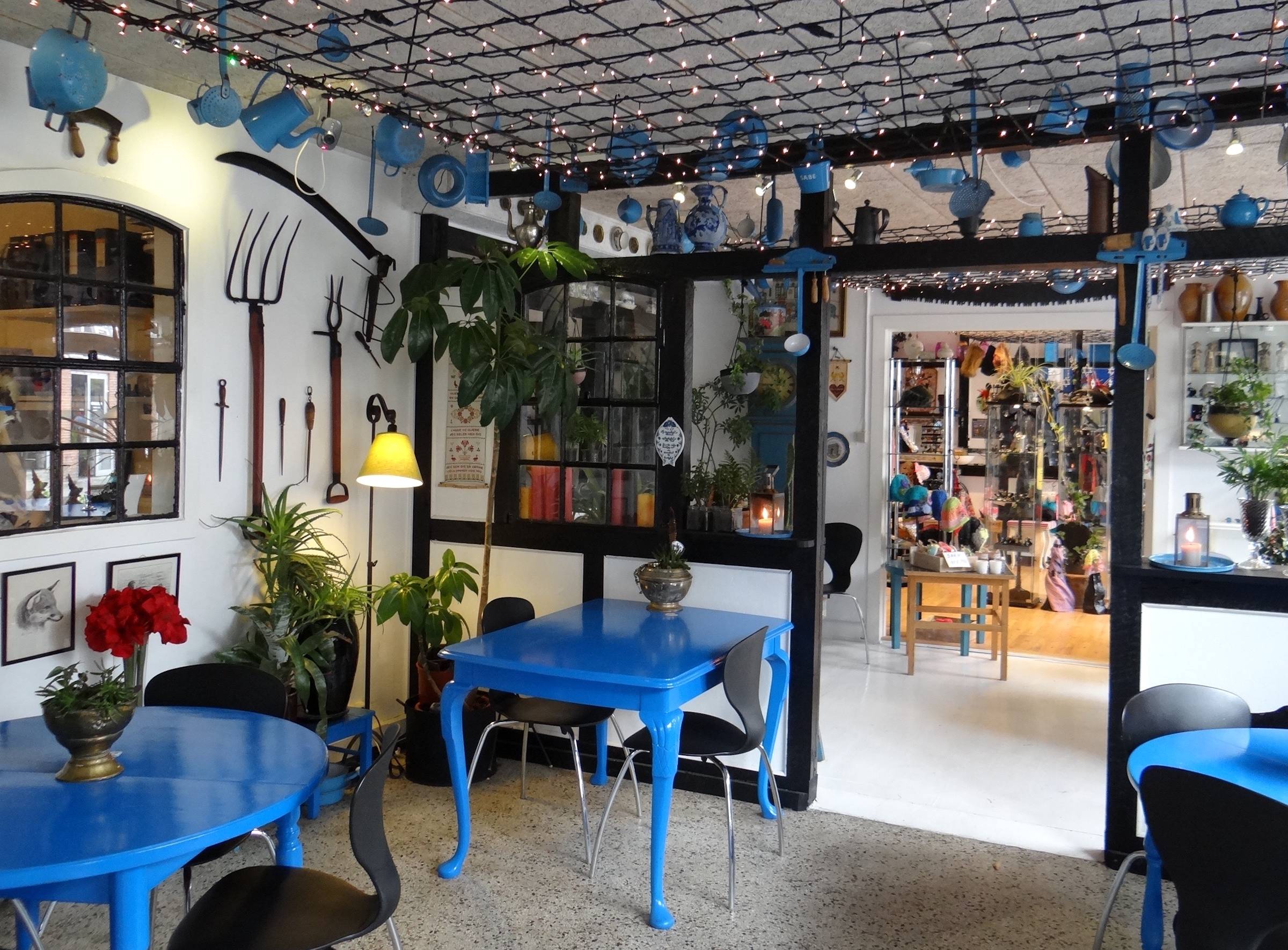 Reichlich dekoriertes Café mit blauen Möbeln