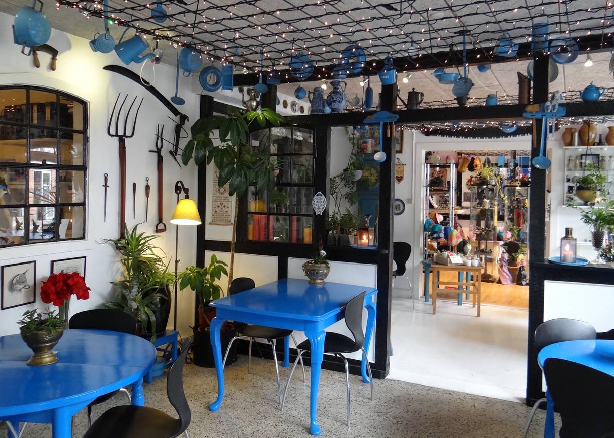 Reichlich dekoriertes Café mit blauen Möbeln