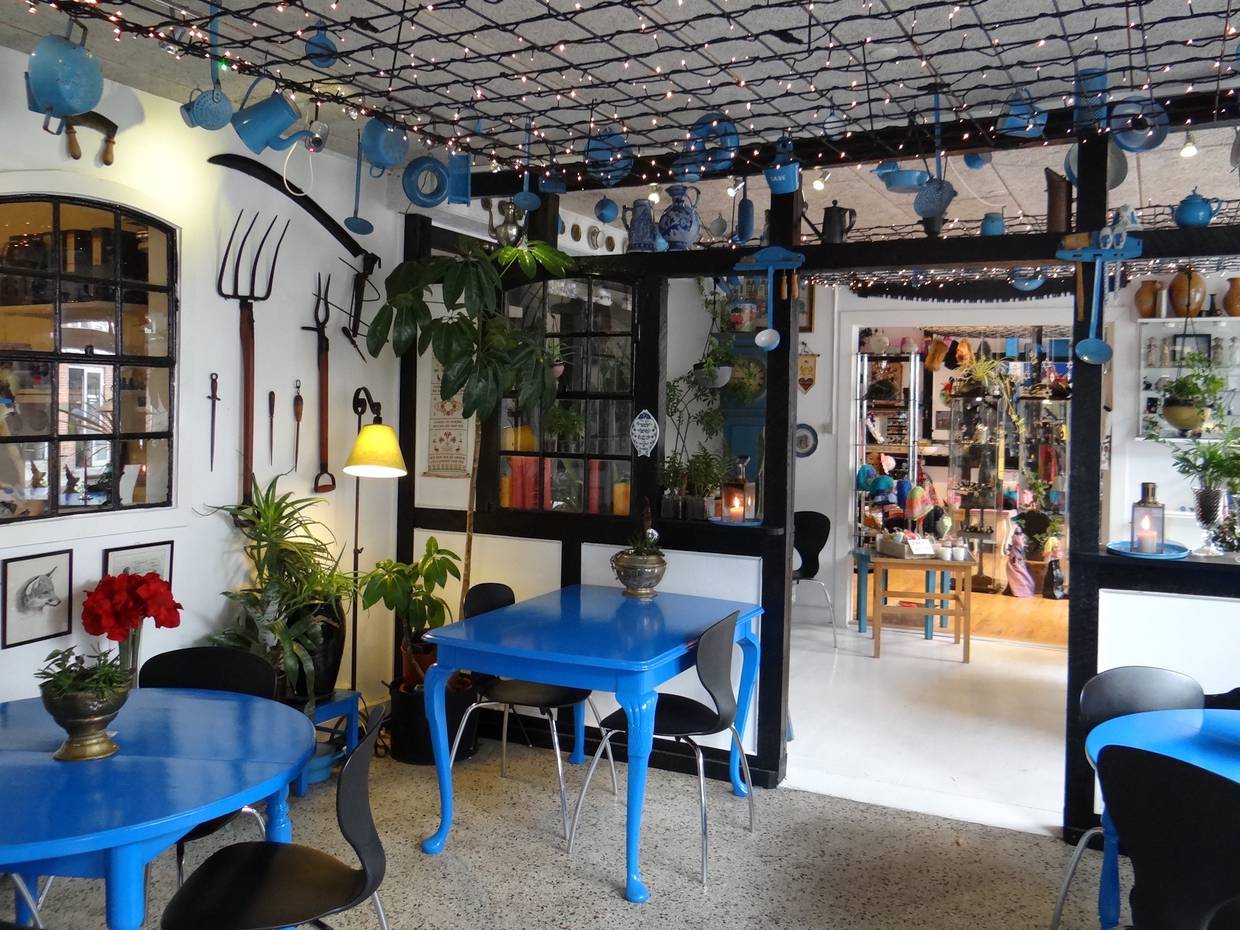 Reichlich dekoriertes Café mit blauen Möbeln
