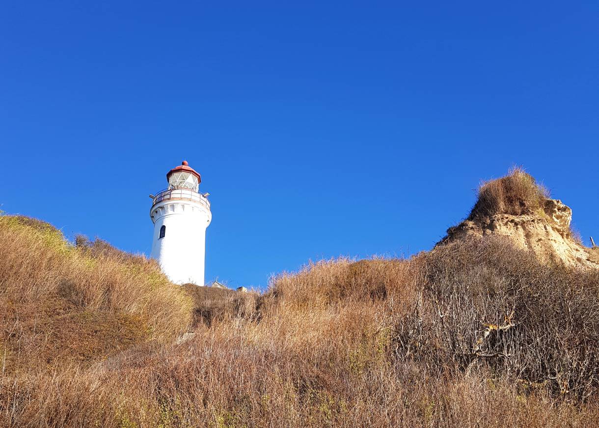 Der kleine, weiße Leuchtturm ragt in den Himmel
