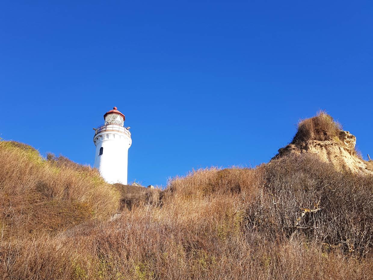Der kleine, weiße Leuchtturm ragt in den Himmel