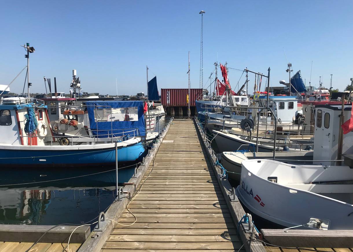 Holzsteg mit kleinen Fischerbooten rechts und links