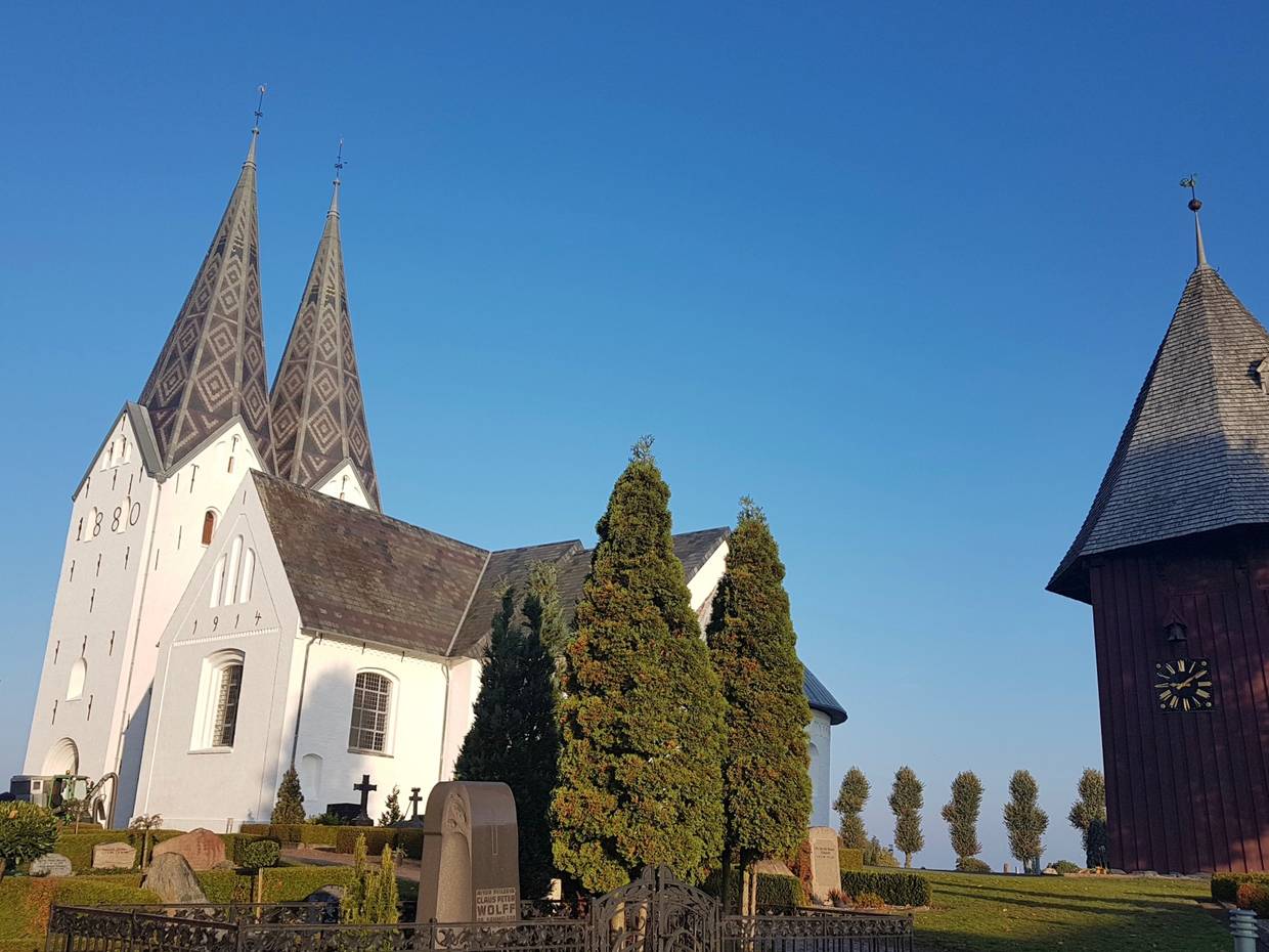 Weiße ,große Kirche mit zwei Kirchtürmen, recht im Bild ein großer Holzturm