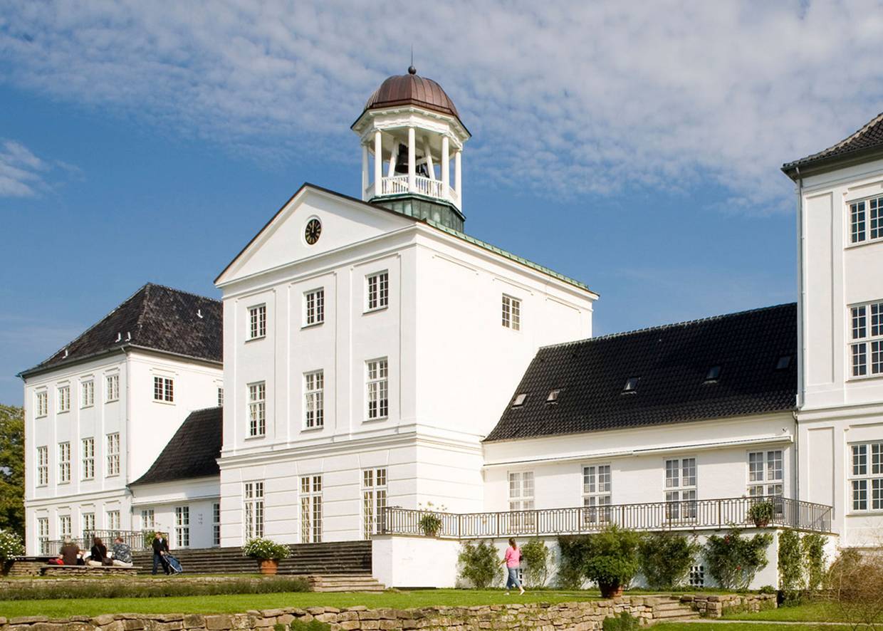 Weißes Schloss mit einem Glockenturm auf dem Dach