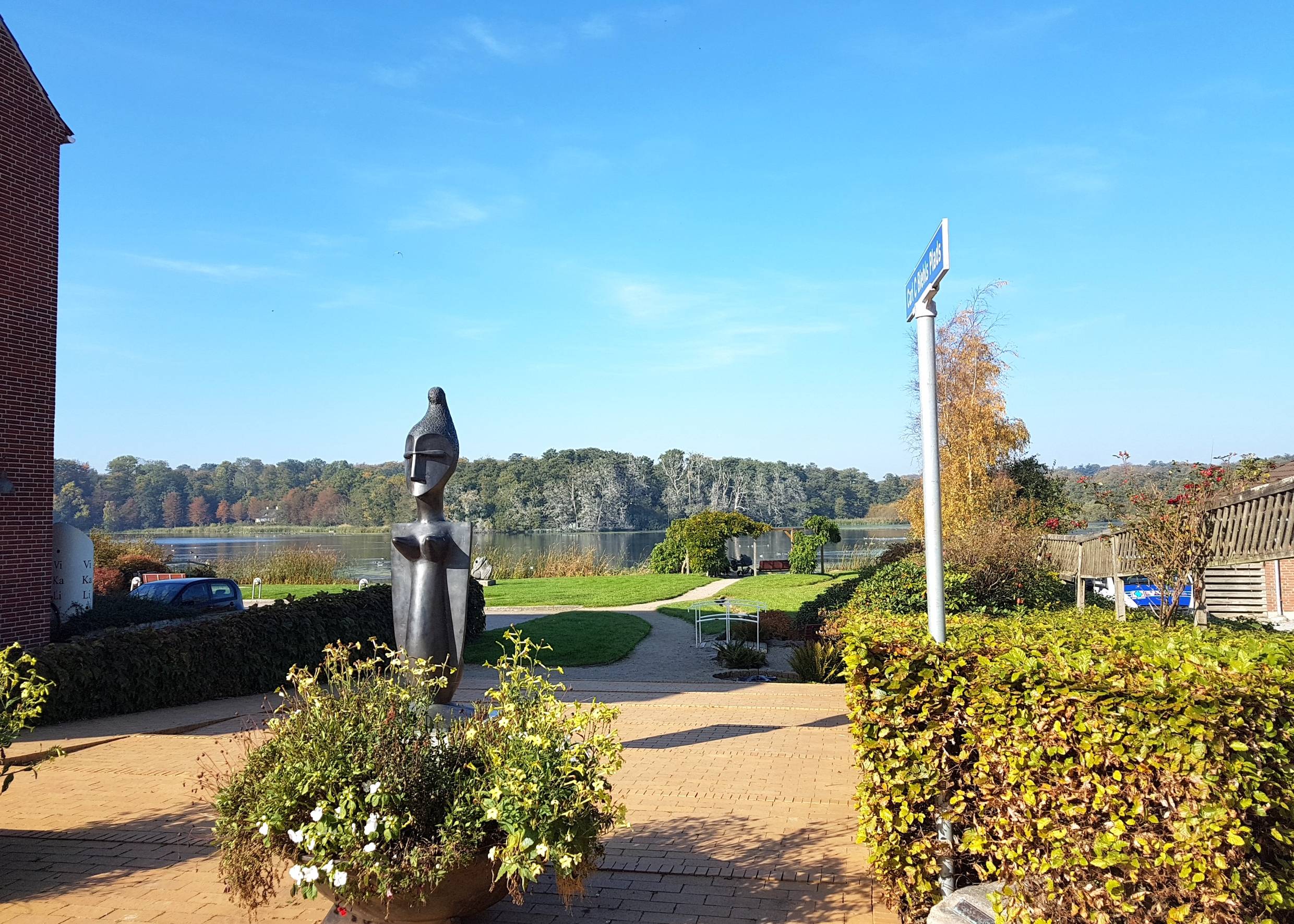 Aussicht über eine kleine Grünanlage zum See