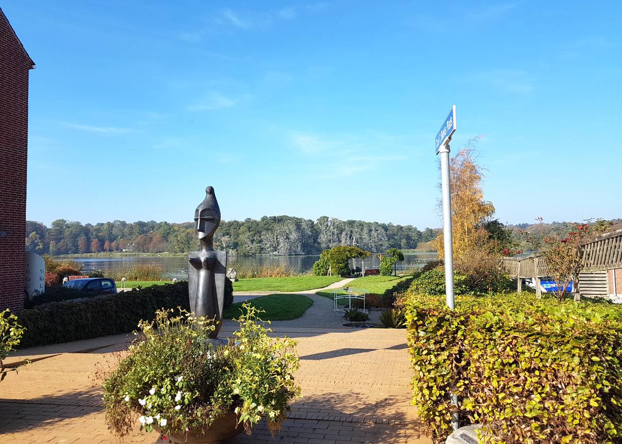 Aussicht über eine kleine Grünanlage zum See
