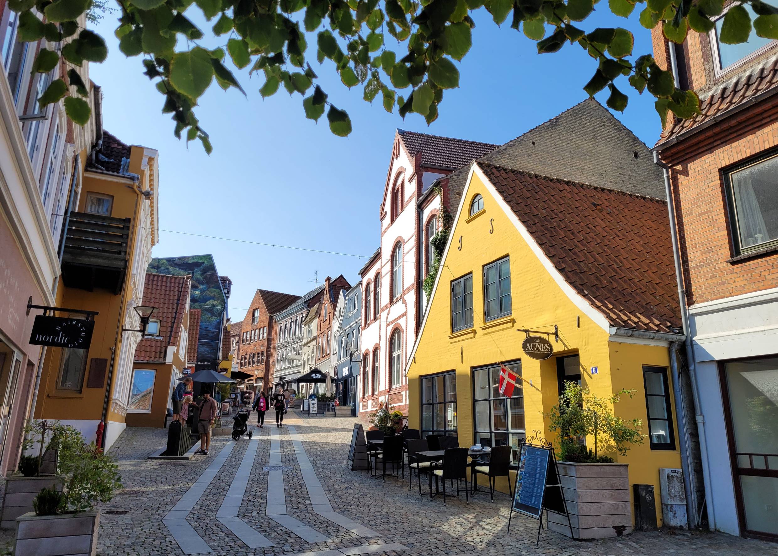 Gelbes altes Hau smit einem Café, dahinter beginnt eine Fußgängerzone