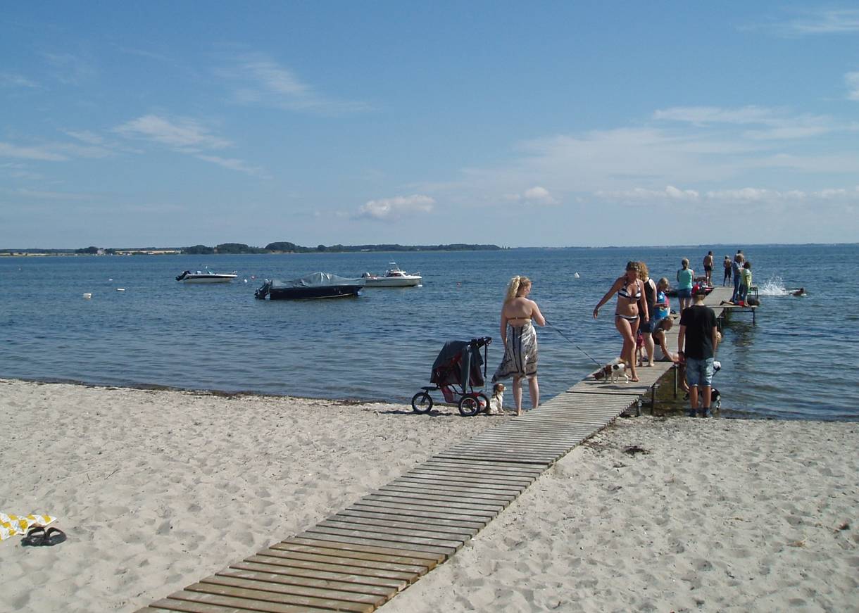 Holzsteg mit vielen Badegästen, Kinderwagen und Hunden an der Ostsee