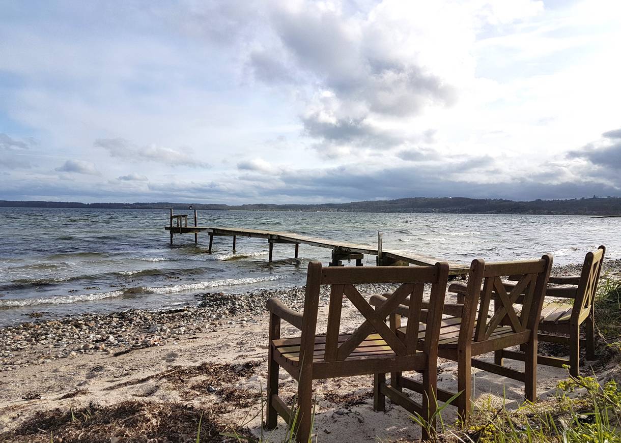 Drei Holzsessel am Meer
