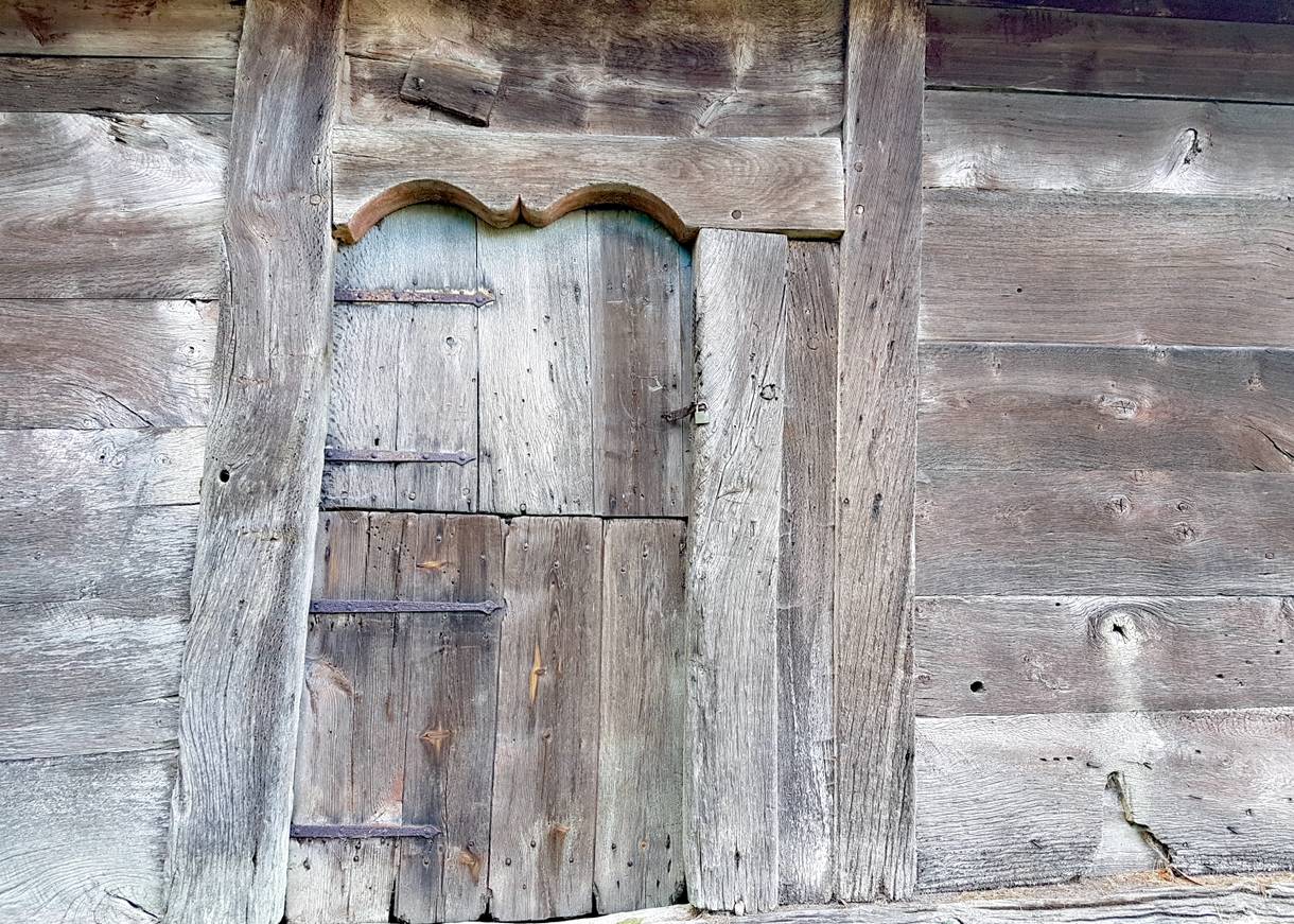 Silbergrauem, sehr alte Holzwand mit einer Tür