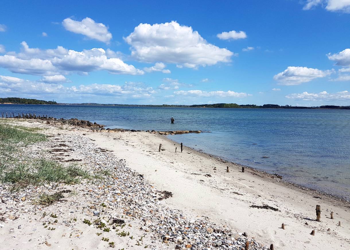 Naturstrand an der flachen Ostsee, Angler im wasser