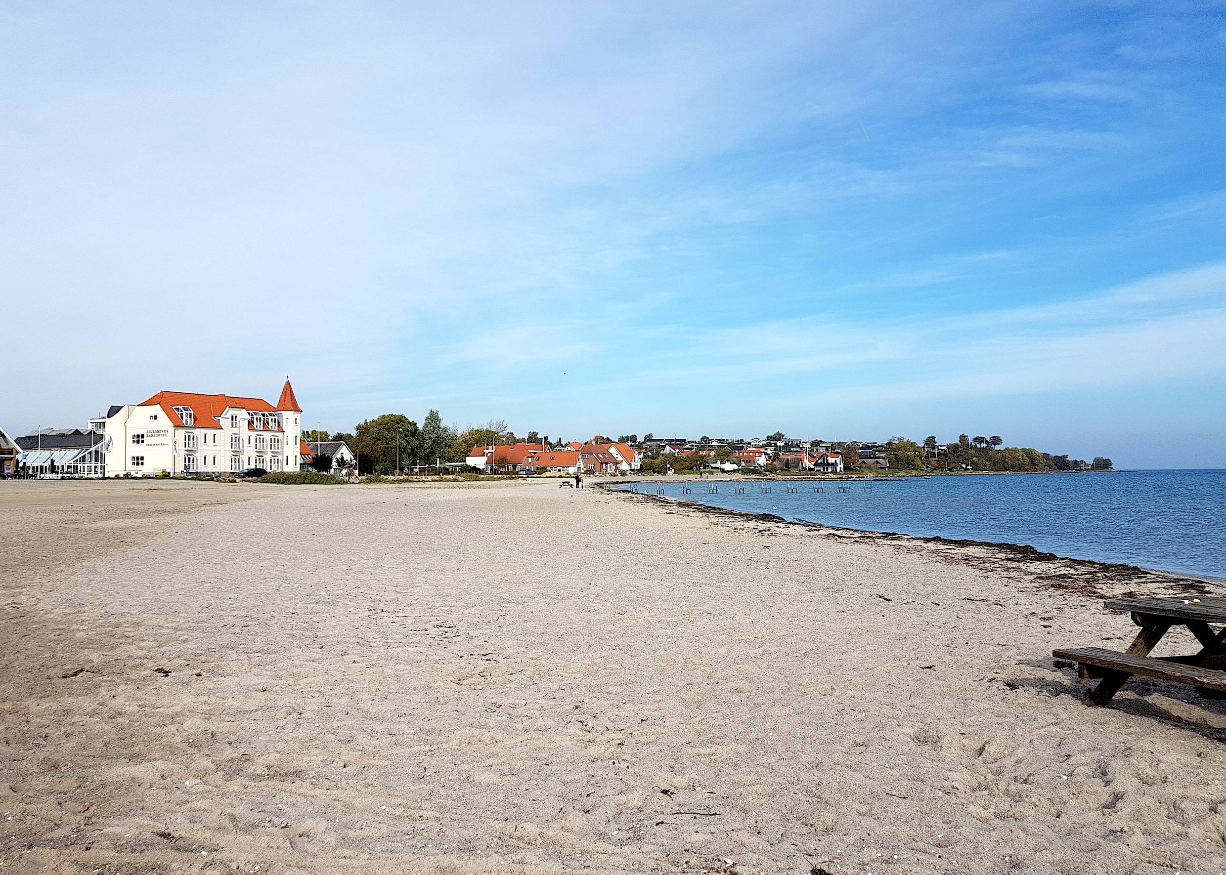 Breiter Ostseestrand mit einem altmodischen Badehotel im Hintergrund