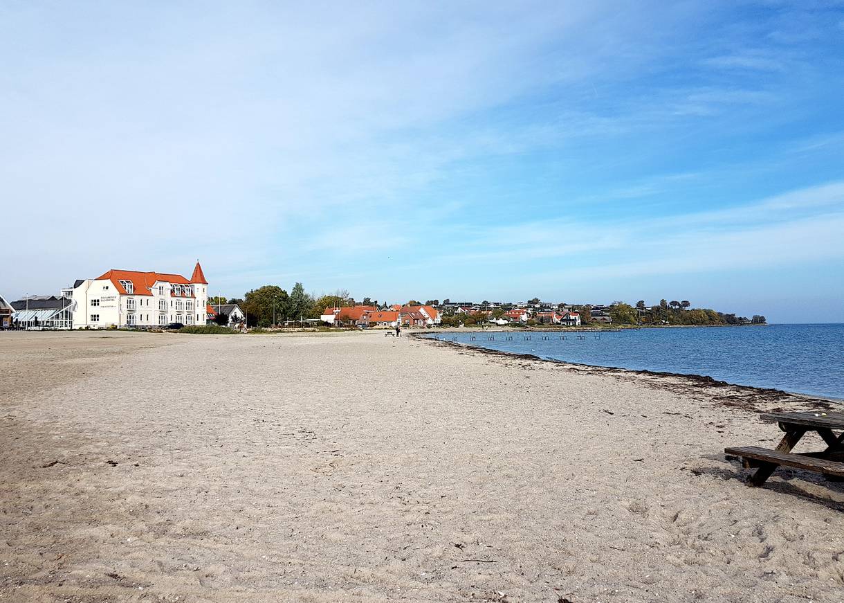 Breiter Ostseestrand mit einem altmodischen Badehotel im Hintergrund