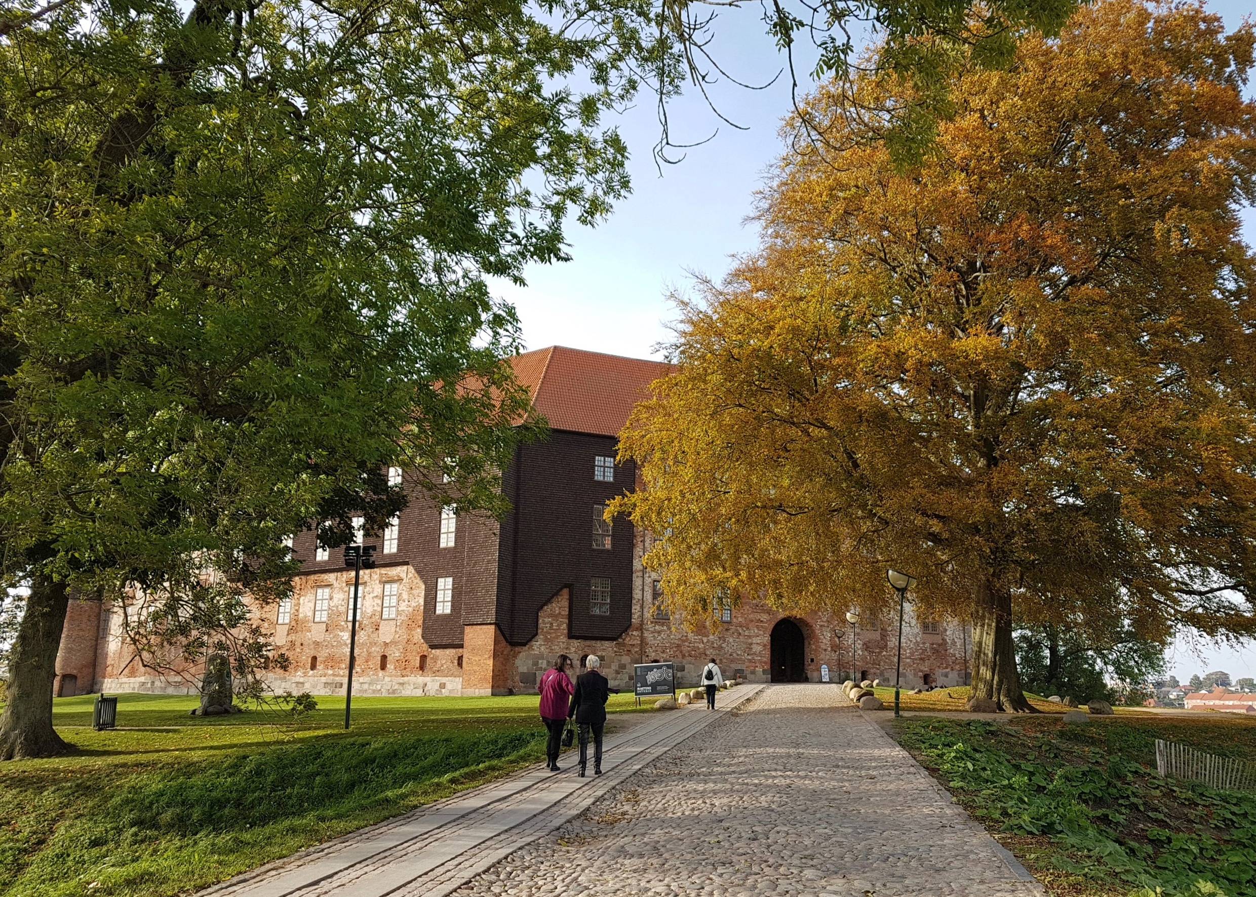 Kopfsteinpflasterweg unter Bäumen zum Eingang von Schloss Koldinghus