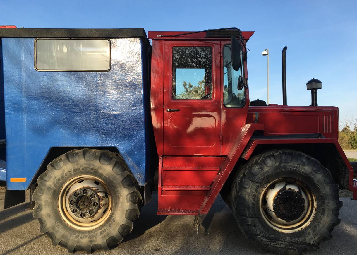 Roter Traktor mit Busaufbau